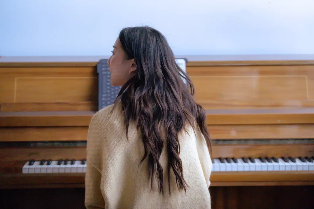 anonymous female playing piano in room