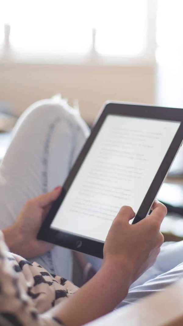 woman sitting on chair using black ipad