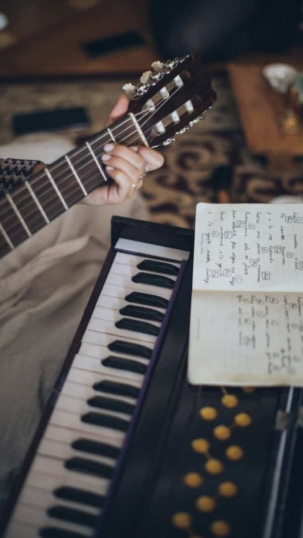 person playing guitar with musical notes